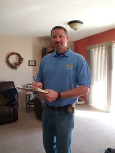 A man in blue shirt holding a white object.