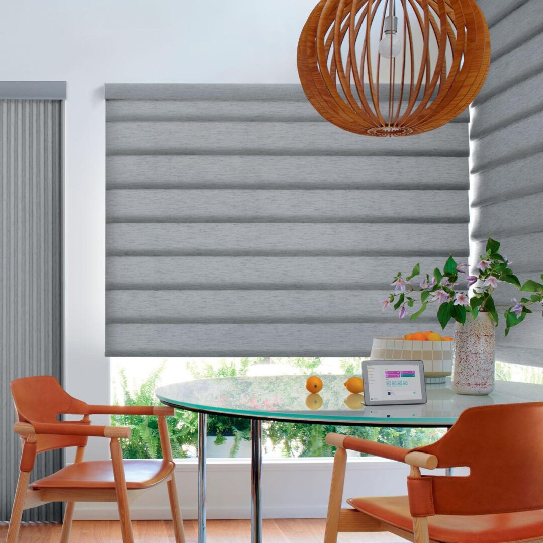 A dining room table with orange chairs and a wooden lamp.