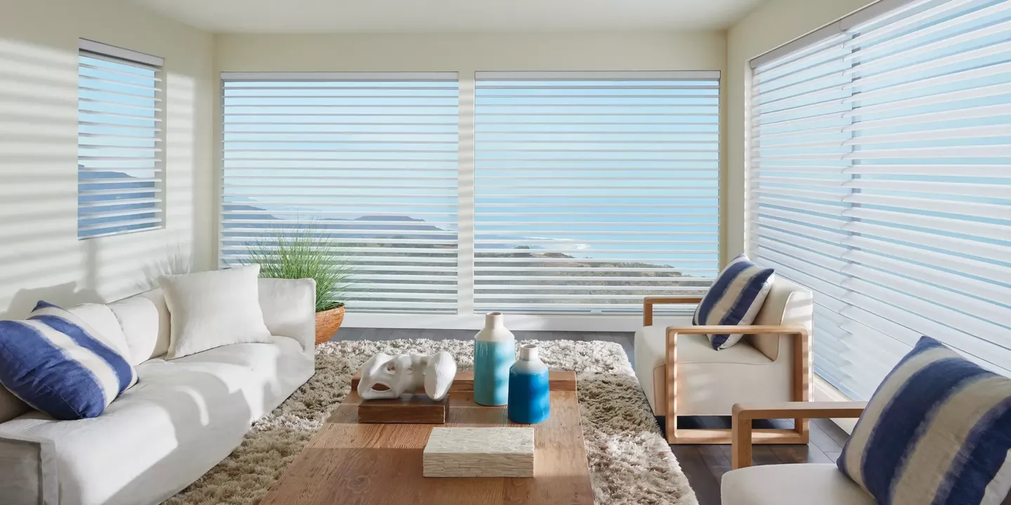 A living room with a large window and ocean view.