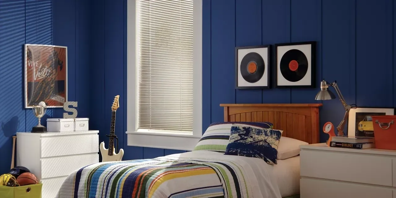 A bedroom with blue walls and white blinds.
