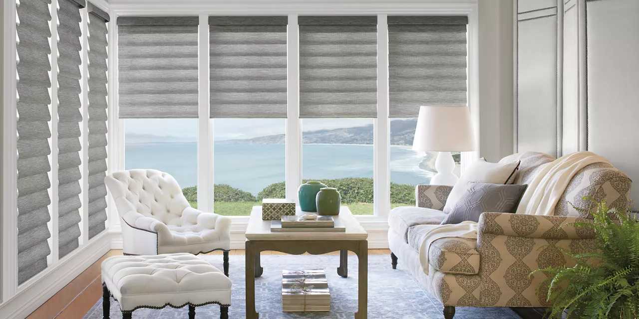 A living room with furniture and windows overlooking the ocean.